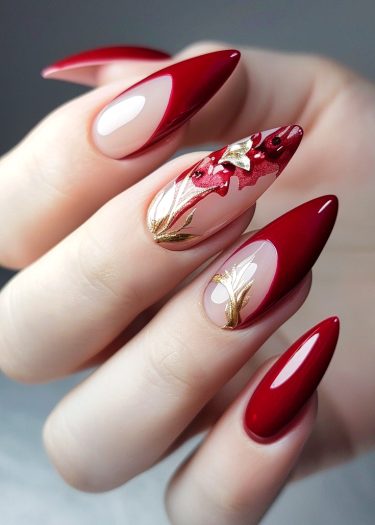 Elegant red stiletto nails with intricate floral and golden designs showcase stunning nail art creativity.