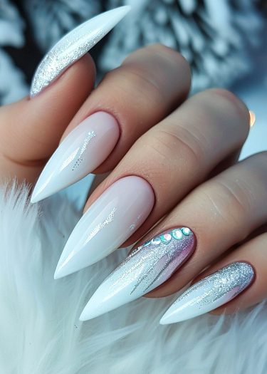 Elegant winter-inspired nails with silver ombre, rhinestones, and snowflake designs for a glamorous look.