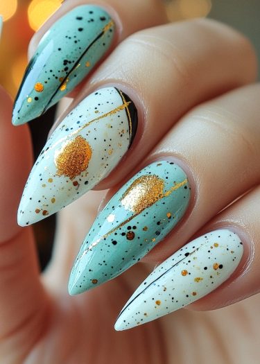 Elegant nail art featuring meticulous speckled designs in blue, white, black, and gold.