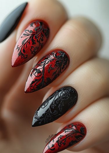 Stunning red and black stiletto nail art featuring intricate lace designs for dramatic elegance.