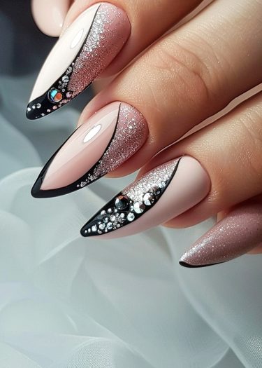 Elegant stiletto nail art featuring glitter, rhinestones, and geometric designs in pale pink.