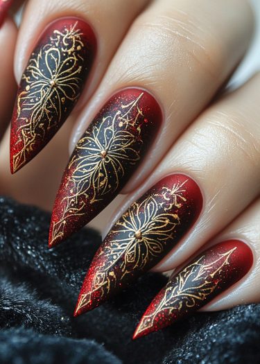 Elegant stiletto nail art with intricate gold designs on a bold black-red gradient.