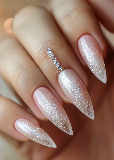 Exquisite stiletto nails with pink ombre and rhinestones in a sophisticated setting.