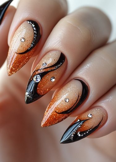 Elegant stiletto nails with a vibrant orange gradient and intricate black swirls and rhinestones.