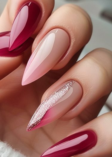 Elegant stiletto nails featuring red, pink, and nude designs; sophisticated and stylish manicure.