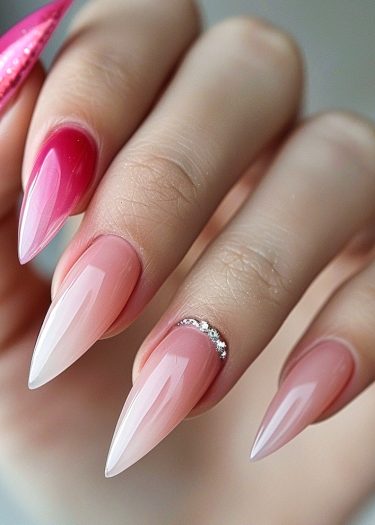 Elegant stiletto nails with pink ombre and gorgeous rhinestone embellishments for a chic look.