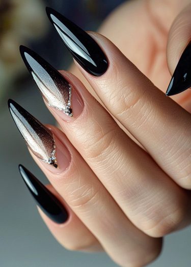 Almond-shaped stiletto nails feature glossy black and sparkling ombre silver designs.