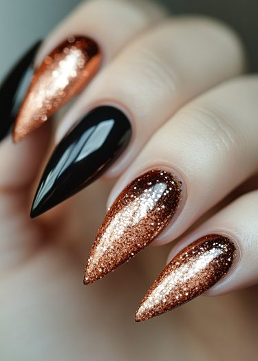 Elegant stiletto nails with glossy black and sparkling copper glitter for a bold manicure.