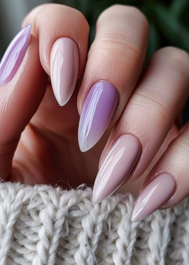 Elegant stiletto nails in lilac and beige with a cozy knitted background for seasonal style.