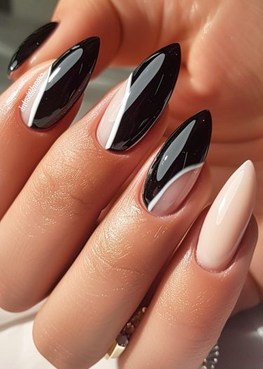 Elegant black and white stiletto nails with intricate designs and glossy finish.