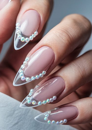 Elegant stiletto acrylic nails with iridescent gems for a glamorous, sophisticated look.