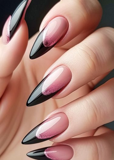 Elegant stiletto nails featuring a stunning pink to black ombre design with glitter.