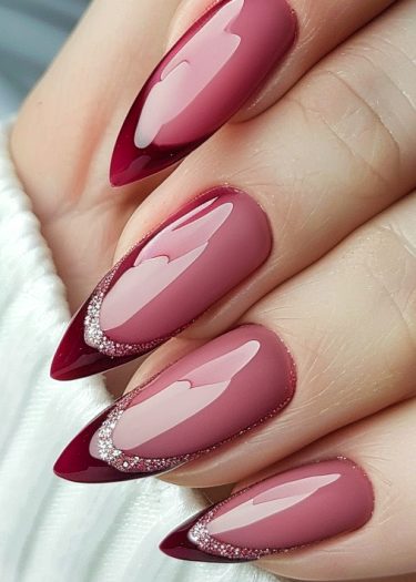 Gradient almond nails in pink and burgundy with glitter accents for elegant nail art.