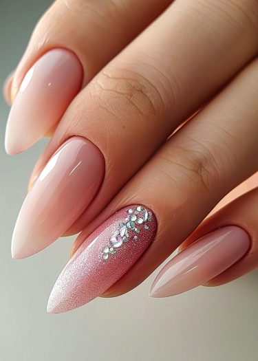 Elegant stiletto nails with gemstone accents and a glamorous pink glitter design.