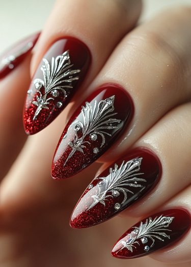 Elegant stiletto red nail art with silver embellishments and rhinestones for a luxurious look.