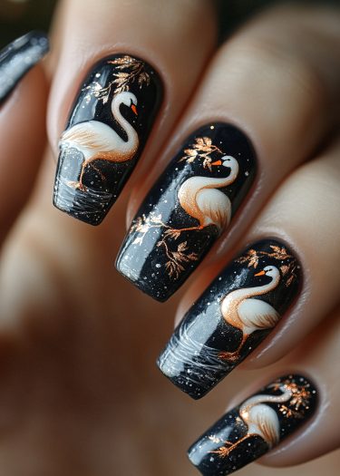 Elegant black nail art featuring detailed swan designs, gold branches, and glittery accents.