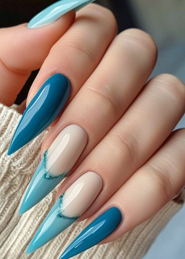 Elegant teal and cream stiletto nails with glitter accents on a cozy knitted background.