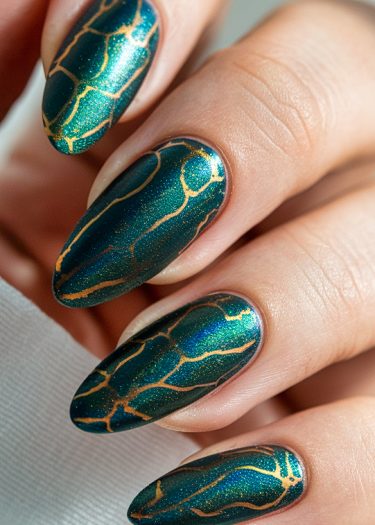 Elegant dark green nail art with golden crackle design, showcasing intricate and polished manicure.