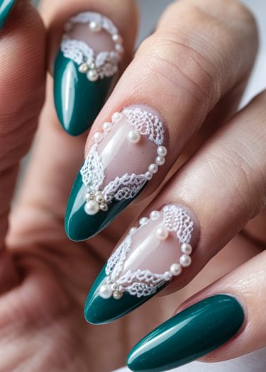 Elegant teal nail art with lace patterns and pearls on almond-shaped nails.