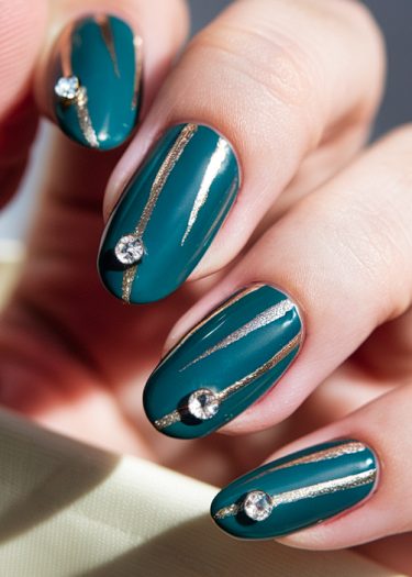 Elegant teal nail art featuring gold lines and rhinestones for a sophisticated manicure.