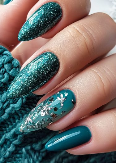 Elegant teal nail art featuring glitter, floral patterns, and a glossy finish.