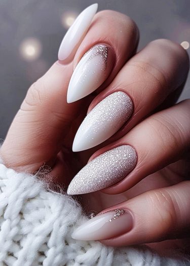 Elegant white and cream almond nails with glitter and rhinestones for a sophisticated manicure.