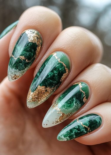 Elegant emerald and gold marble nail art design on almond-shaped nails.