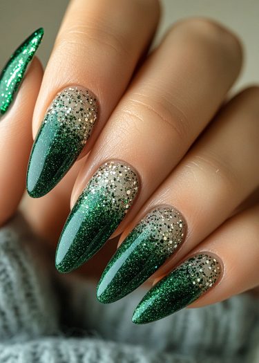 Elegant emerald green gradient nails with silver glitter for festive celebrations.