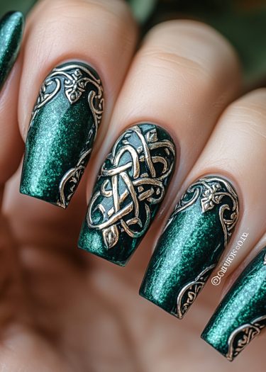 Elegant emerald green metallic nail art with intricate golden Celtic designs and embossed patterns.