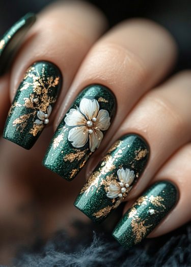 Exquisite emerald green nail art featuring floral designs and gold accents for a luxurious look.