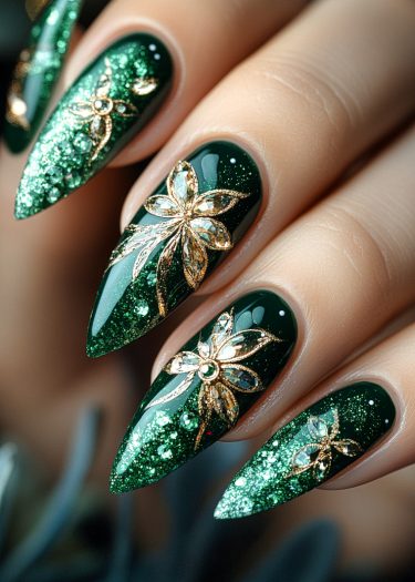 Elegant emerald green nail art with gold floral designs and sparkling glitter accents.