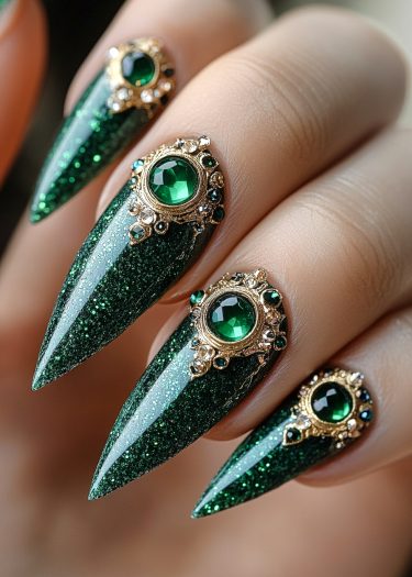 Exquisite emerald-green stiletto nails adorned with sparkling gemstones and luxurious gold settings.