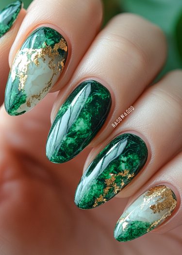 Elegant emerald marble nail art with gold accents in a chic almond shape design.