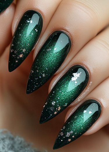 Elegant emerald stiletto nails with shimmering sparkles and a high-gloss finish.