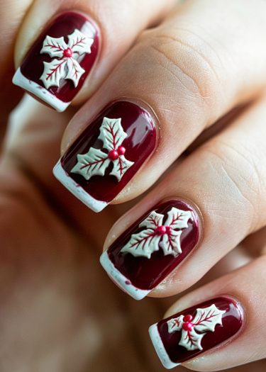 Elegant burgundy holiday nail art featuring festive holly leaves and red berries.