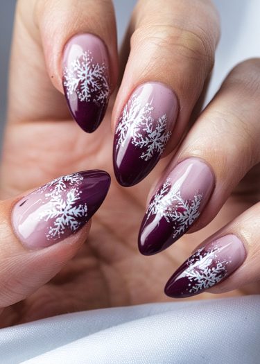 Elegant festive pink and burgundy almond nails with snowflake designs and glossy finish.