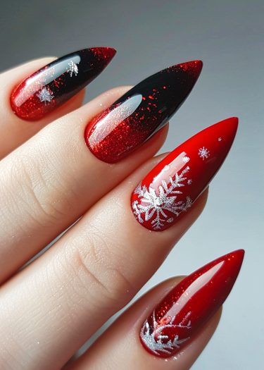 Stunning red and black stiletto nails with sparkling silver snowflake designs for a festive look.