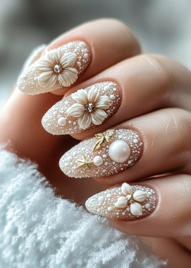 Elegant 3D floral manicure with pearls and golden accents on almond-shaped nails.