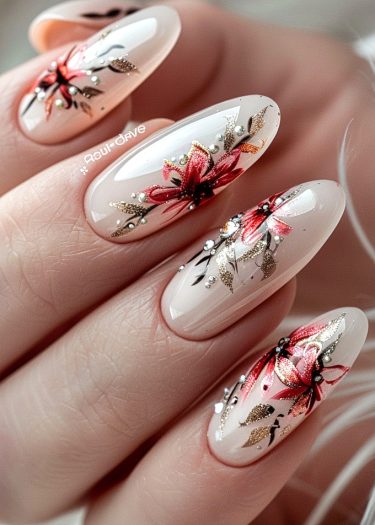 Elegant floral nail art with red flowers and gold accents on nude almond-shaped nails.