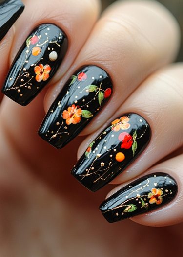 Elegant floral nail art on a glossy black base with vibrant orange and red designs.