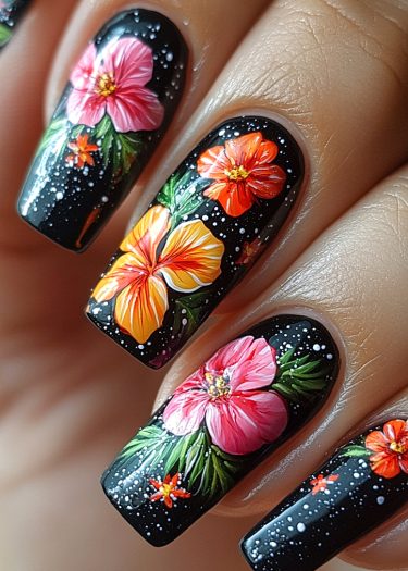 Vibrant floral nail art on glossy black nails featuring detailed flowers and sparkling accents.