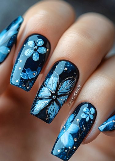 Elegant blue floral nail art design on glossy manicured nails with intricate details.