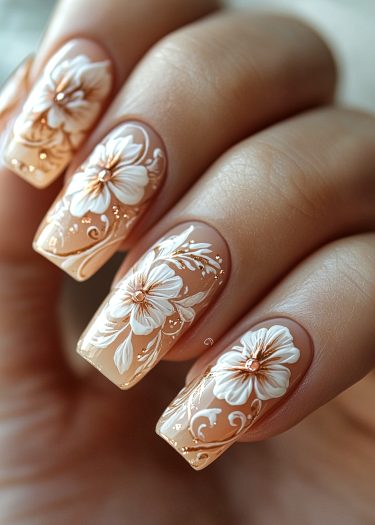 Elegant nude nail art featuring white flowers and gold accents for a sophisticated look.