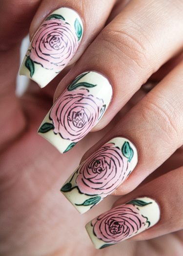 Elegant floral nail art with pink roses and green leaves on off-white background.