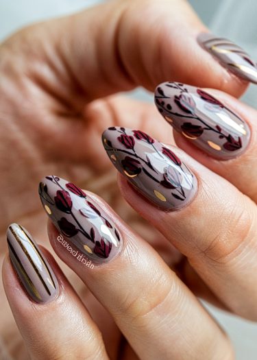 Elegant floral nail art design with glossy taupe base and intricate red and gold patterns.