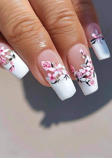 Elegant floral nail art design with rhinestones on a pink ombre base.