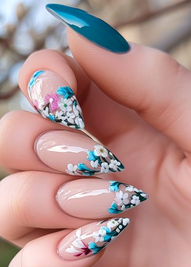 Elegant floral stiletto nails with teal accents and intricate designs in vibrant colors.