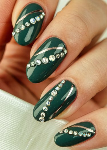 Elegant forest green nails with rhinestones and silver glitter design for sophisticated nail art.