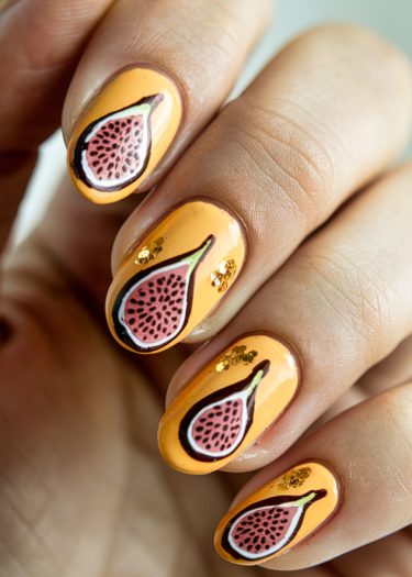 Vibrant fruit-themed nail art featuring fig slices with golden accents and orange base polish.