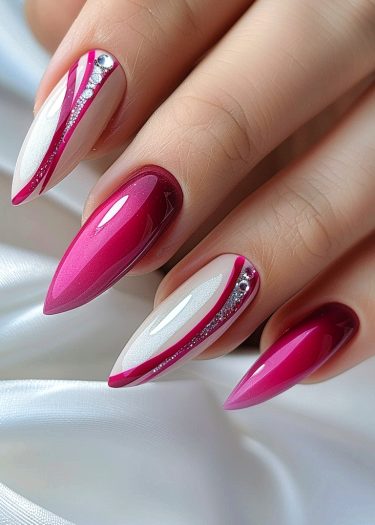 Elegant pink and white almond-shaped nails with rhinestones on a silky backdrop.